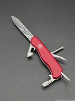 Knife with large blade, can opener and reamer open