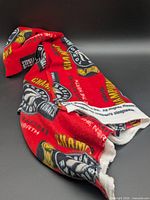 Unfolded view of the red fleece fabric showing logos and text