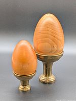 Two wood eggs on brass stands front view