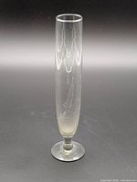 Full view of clear glass bud vase showing etched leaf design and footed base