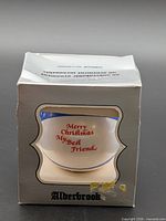 Front of Alderbrook box showing ornament with red script greeting