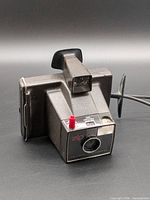 Front view showing lens, red shutter button and Zip branding