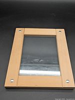 Front view of wooden frame showing glass and screw accents