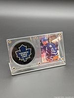 Front view of acrylic display showing Toronto Maple Leafs logo puck beside Wendel Clark photo