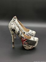 Left side view of both platform pumps showing newspaper print and Union Jack graphics