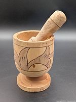 mortar and pestle upright, showing carvings