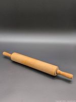 Full view of wooden rolling pin on dark background