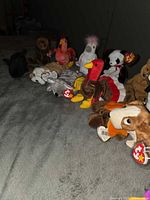Row of Beanie Babies on bed showing variety and tags
