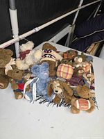 Group of Boyds plush toys stacked on tapestry blanket