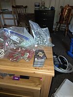 Top view of craft supplies including bags of decorative stones, card deck, cord coil and candle