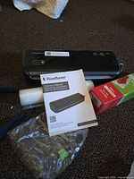 FoodSaver FM2000 unit, loose roll, manual, plastic bag, boxed roll partially visible