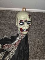 Close-up of plastic zombie head with tattered fabric body