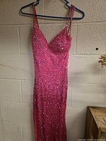 Front view of full-length pink sequin dress on hanger