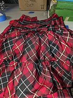 Front view of red-black plaid children’s dress with bow detail