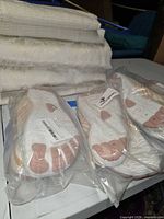 Four sealed pairs of white water shoes on table