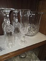 Five of the six champagne flutes and the crystal ice bucket on shelf