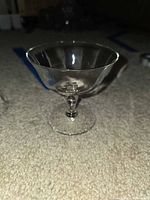 single clear glass coupe champagne stem viewed from side
