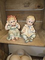 Both Leflon bisque piano baby figurines on shelf