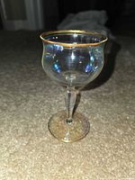 Single optic stemmed wine glass showing gold rim and foot