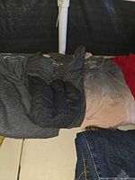 Four women’s shirts displayed flat: dark grey, charcoal, blush pink, red; visible American Eagle and Bullhead labels.