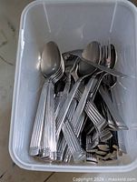 Bin filled with mixed stainless cutlery pieces