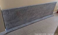 Full view of countertop with attached backsplash set upright against wall