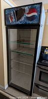 Full view of Pepsi cooler beside stove