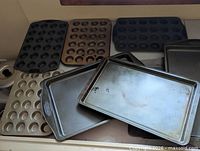 Group of muffin tins and baking sheets arranged on stovetop