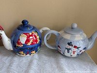 Both Christmas teapots side by side