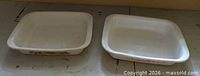 Two rectangular Corning Ware dishes side by side showing relative size and patterns