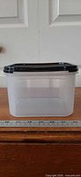 Front view of clear container with black lid