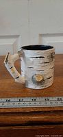 Front view of birch bark mug showing trunk texture and ruler for scale