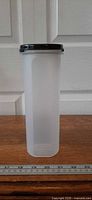 Full front view of clear container with black lid