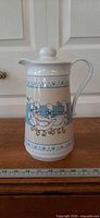 Front view of white plastic thermal carafe with Ribbon Geese pattern
