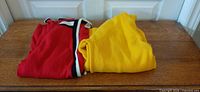 Red and yellow folded cardigans side by side
