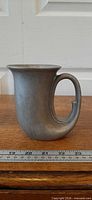 Front view of pewter horn mug with ruler for scale