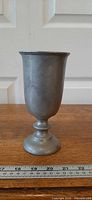 Front view of pewter goblet standing on wood surface