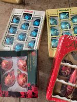 Three boxes of ornaments: two teal Holly boxes and one red & gold assorted box