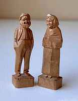 Front view of both carved figures on bases