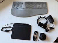Full lot view showing keyboard, tablet with pen and cable, 3D mouse, hub with power adapter