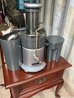 Front view of Breville Juice Fountain juicer with pulp container and juice jug on table