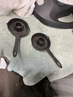 Two cast iron candle holders on towel, overhead view