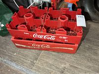 Two nested red Coca-Cola bottle crates showing logos and general wear