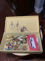 Open box showing assortment of costume jewelry pieces