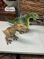 Both dinosaur toys side by side on table