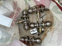 All four door knob sets inside bag showing knobs, latches, and strike plates