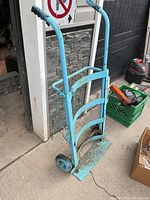 Full view of blue barrel hand truck standing upright