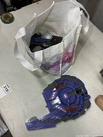 Bag containing loose Mega Bloks bricks and separated partial model visible on table