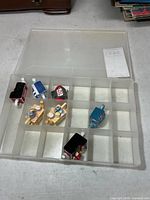 Organizer box with miniature teapots placed in compartments