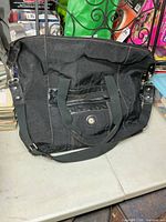 Front view showing nylon body, leather pocket, Mouflon logo, dual handles and shoulder strap
